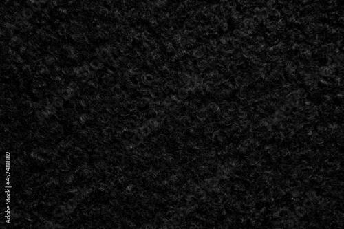 Black astrakhan background from warm woolen fabric