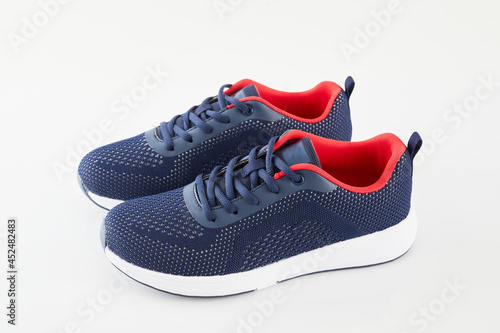 Pair of new unbranded blue running shoes or sneakers isolated on white background. Fashion sport footwear or trainers for fitness.