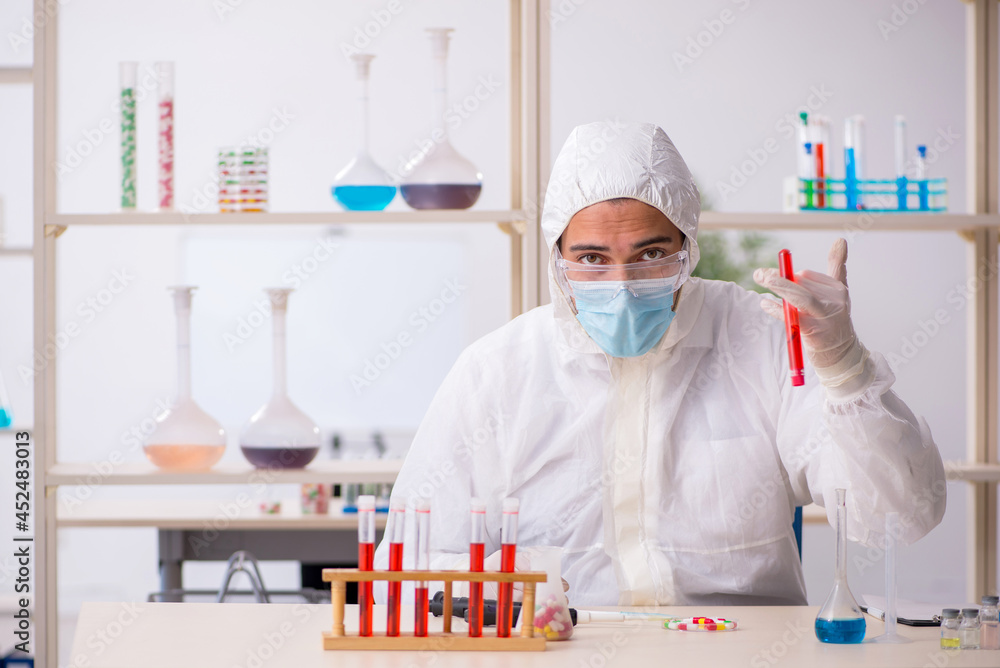 Young male chemist in drugs syntesis concept Young male chemist in drugs syntesis concept