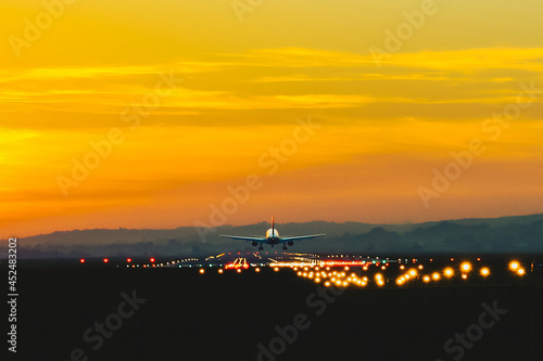 The plane takes off from the airport runway during sunset at dusk © Bogdan