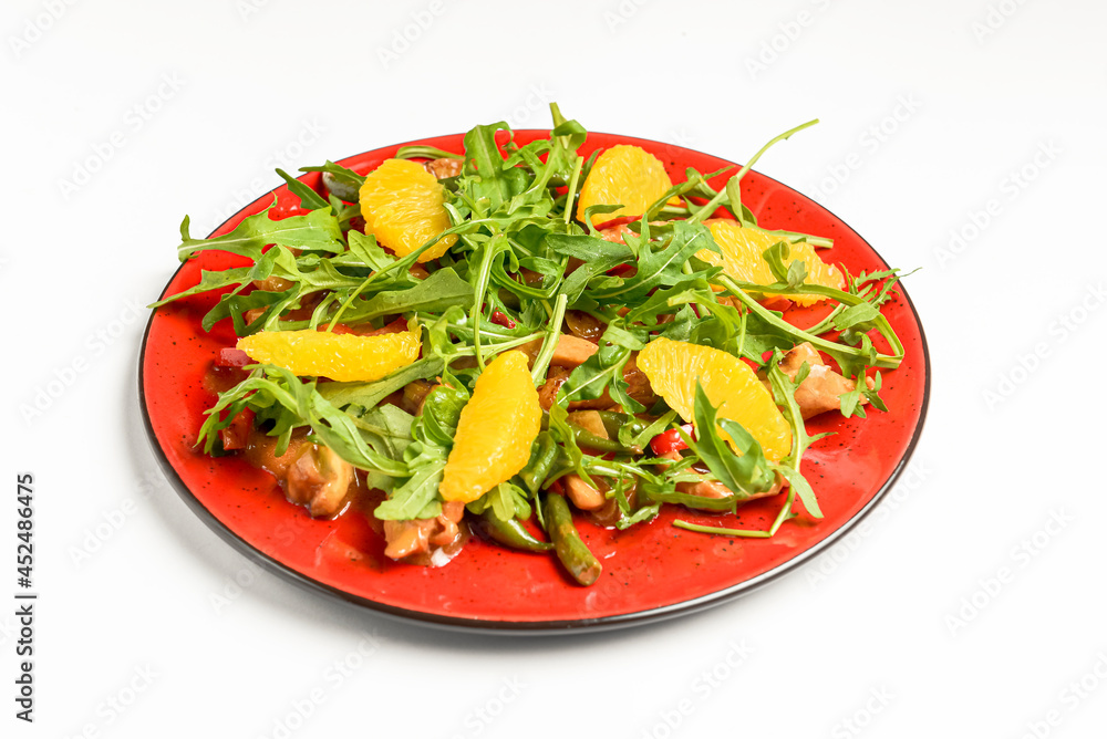 Delicious mixed vegetable and fruit salad served in a red plate over white background.