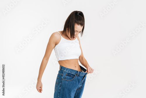 European brunette shocked woman posing in big jeans