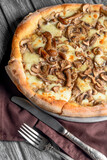 Appetizing pizza with mushrooms on a rustic wooden background. Delicious vegetarian pizza.