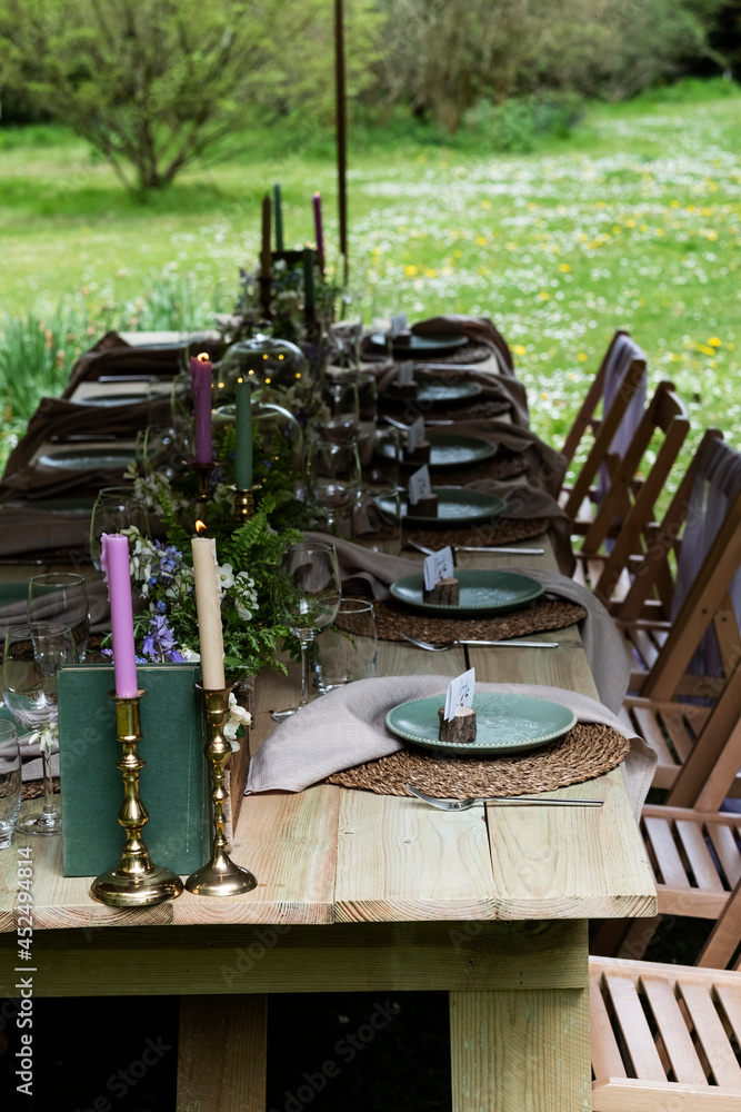 Dining table with candles and rustic place settings for a woodland naming ceremony. Dining table with candles and rustic place settings for a woodland naming ceremony.