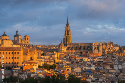 Cityscape in old city with colorful clouds at sunset; Cathedral and old town of Toledo, World Heritage Site, Spain. Close up horizontal view