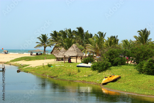 Shore of Paradise Beach, Pondicherry, India. Golden sands, Cocount palms and  rattan shaded areas photo