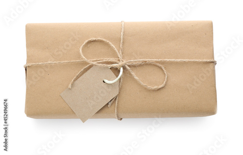 Parcel wrapped with kraft paper, twine and tag isolated on white, top view