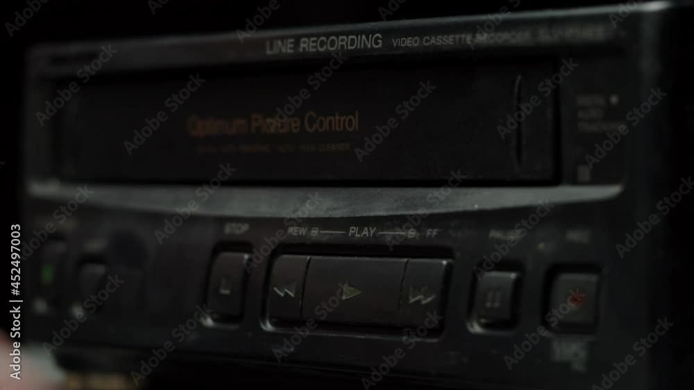 Putting video cassette into recorder. Old retro television with blue screen on black background. Old-fashioned TV, tv setting concept, ripples and interference, searching channel. Putting video cassette into recorder. Old retro television with blue screen on black background. Old-fashioned TV, tv setting concept, ripples and interference, searching channel.