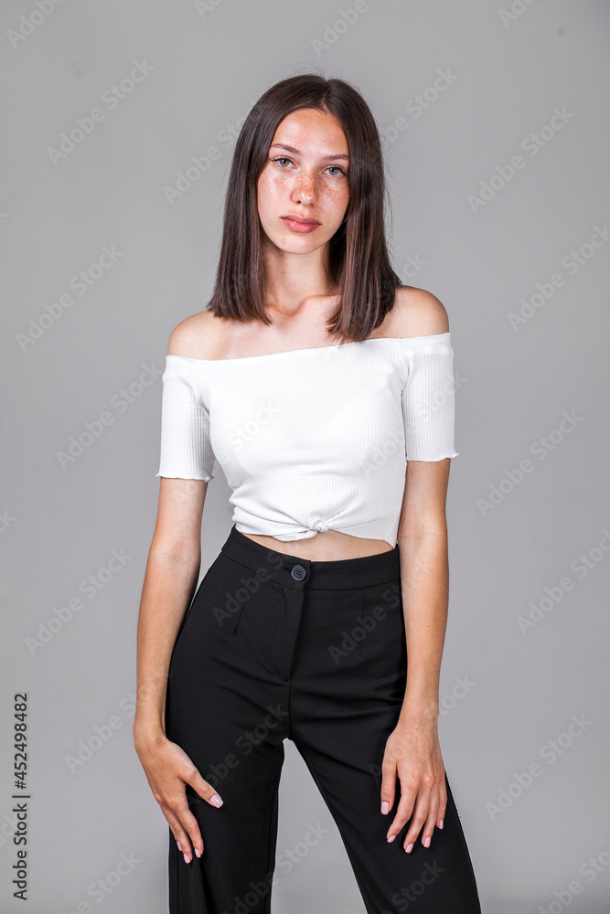 Young beautiful girl in studio isolated on gray background