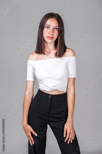 Young beautiful girl in studio isolated on gray background