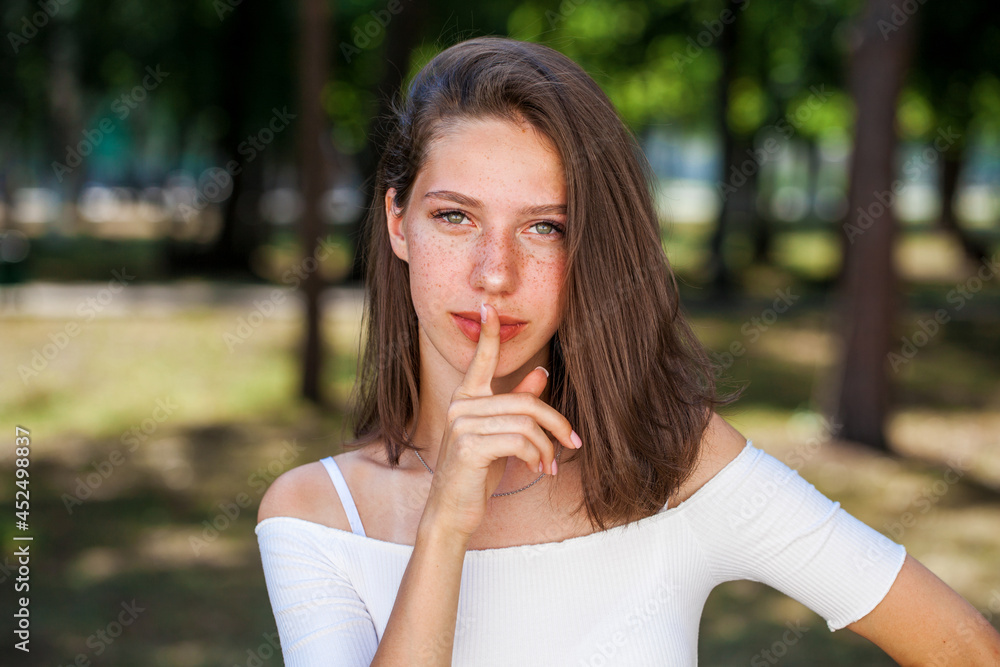 Young beautiful brown-haired girl with freckles on her face Young beautiful brown-haired girl with freckles on her face
