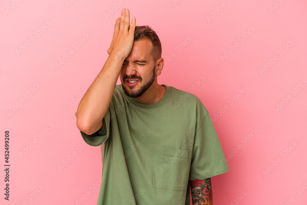 Young caucasian man with tattoos isolated on pink background forgetting something, slapping forehead with palm and closing eyes. Young caucasian man with tattoos isolated on pink background forgetting something, slapping forehead with palm and closing eyes.