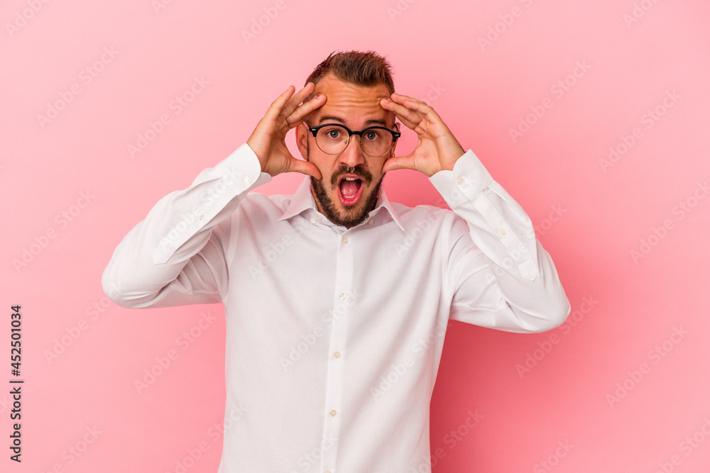 Young caucasian man with tattoos isolated on pink background receiving a pleasant surprise, excited and raising hands. Young caucasian man with tattoos isolated on pink background receiving a pleasant surprise, excited and raising hands.