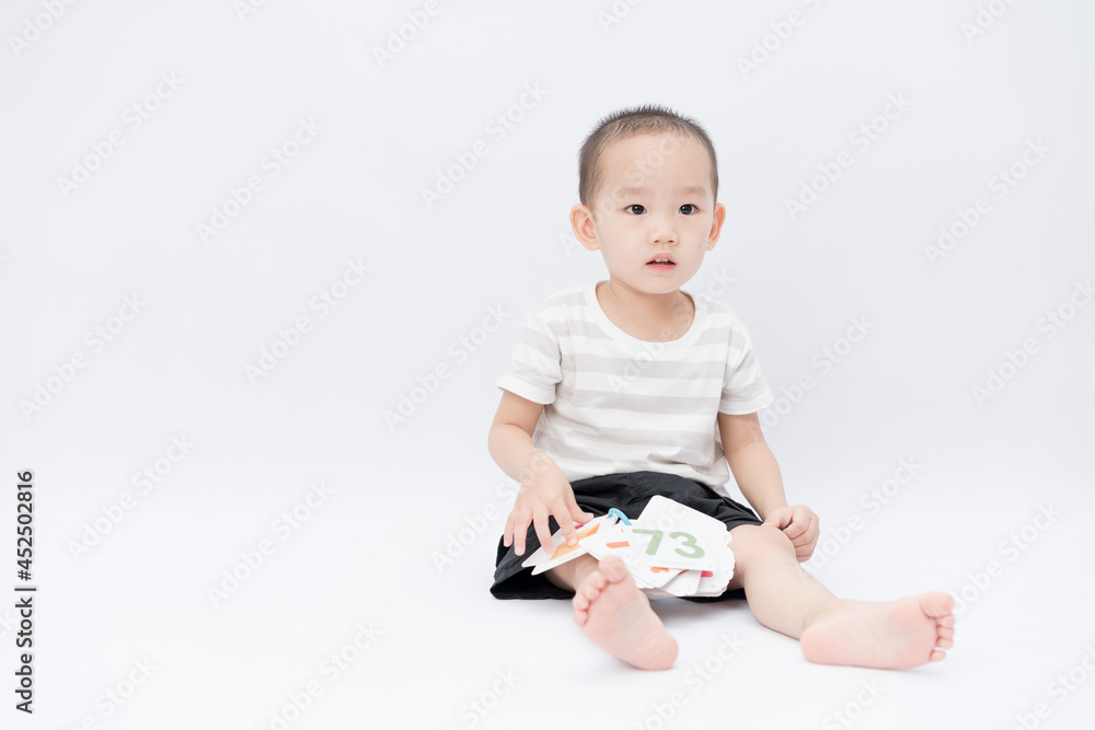 A little asian boy takes a portrait in a white background shed A little asian boy takes a portrait in a white background shed