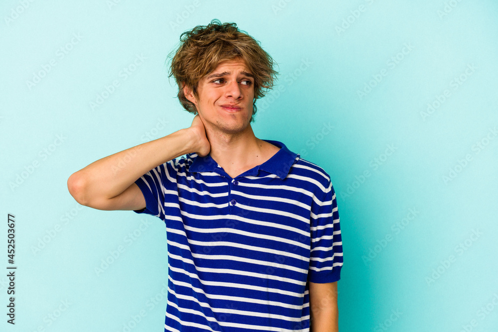 Young caucasian man with make up isolated on blue background touching back of head, thinking and making a choice. Young caucasian man with make up isolated on blue background touching back of head, thinking and making a choice.