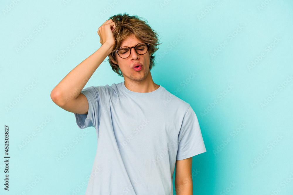 Young caucasian man with make up isolated on blue background tired and very sleepy keeping hand on head. Young caucasian man with make up isolated on blue background tired and very sleepy keeping hand on head.