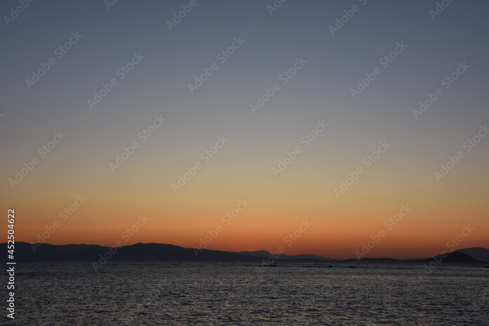 sunset on the sea over the port in Aegina in Greece
