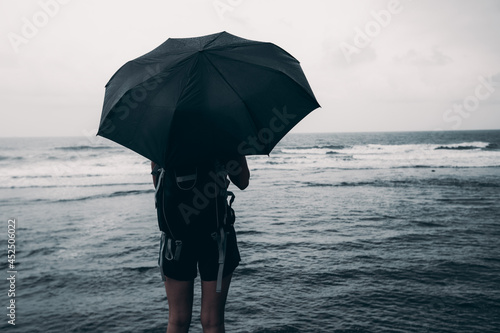 Woman with umbrealla stand in the storm at seaside