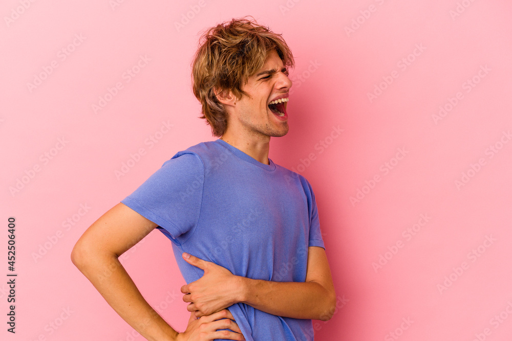 Young caucasian man with make up isolated on pink background suffering a back pain. Young caucasian man with make up isolated on pink background suffering a back pain.