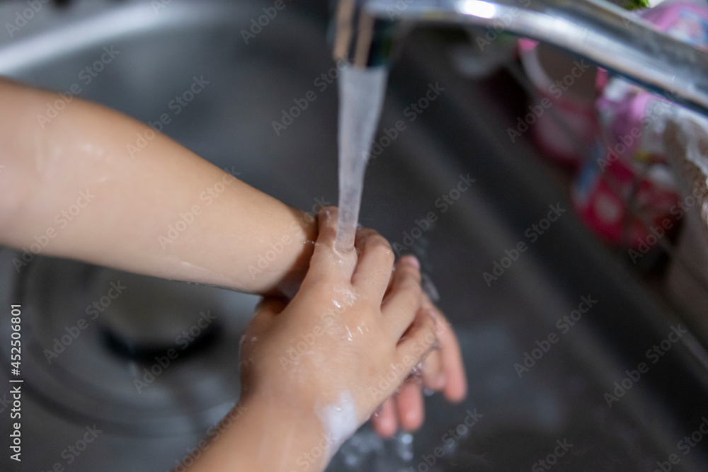 ウイルス感染を防ぐために水道でしっかり手を洗う子供 ウイルス感染を防ぐために水道でしっかり手を洗う子供