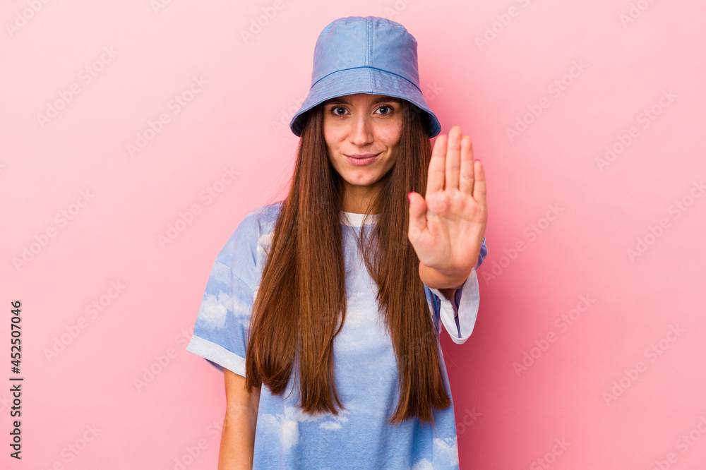 Young caucasian woman isolated on pink background standing with outstretched hand showing stop sign, preventing you. Young caucasian woman isolated on pink background standing with outstretched hand showing stop sign, preventing you.