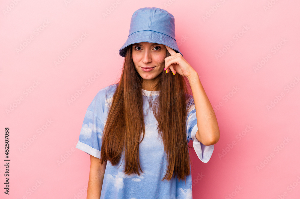 Young caucasian woman isolated on pink background pointing temple with finger, thinking, focused on a task. Young caucasian woman isolated on pink background pointing temple with finger, thinking, focused on a task.