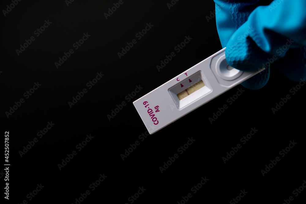 Obraz premium Hand with glove holding Rapid kits of Covid-19 Ag test or ATK