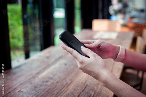 Connection technology background from hand holding mobile with empty screen for text in cafe. 