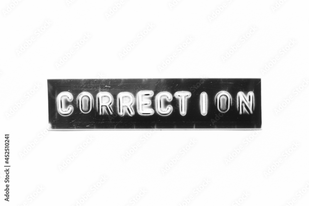 Embossed letter with word correction in black banner on white paper background Embossed letter with word correction in black banner on white paper background
