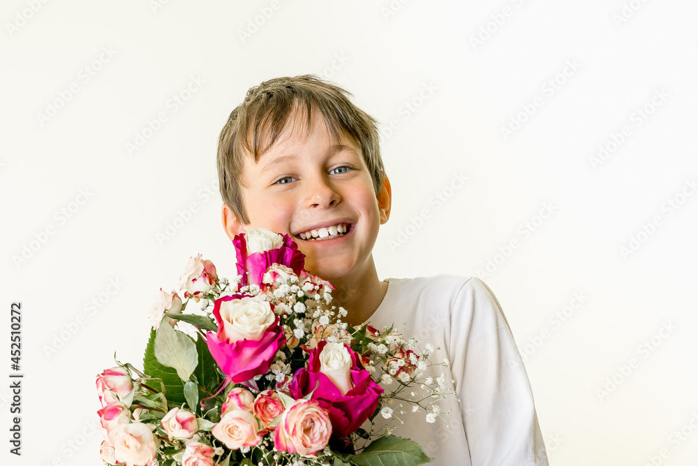 A bouquet of flowers in the hands of a smiling eight-year-old boy. Greeting card mockup with copy space A bouquet of flowers in the hands of a smiling eight-year-old boy. Greeting card mockup with copy space