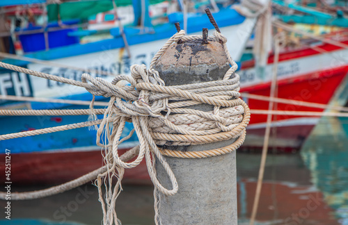 Rope bollard jetty or rope tied up on a pole on a wooden dock photo