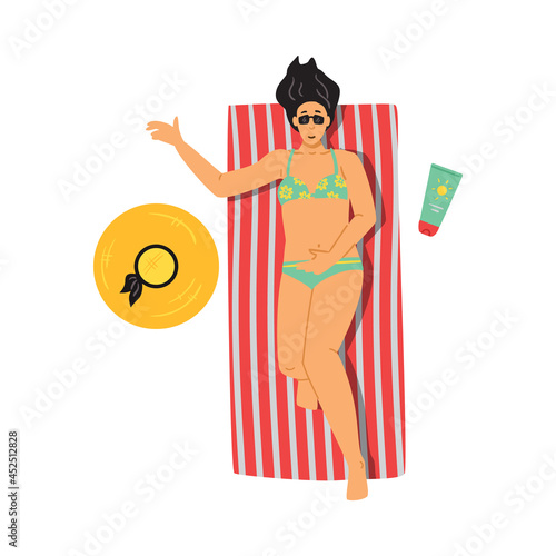 Young woman in swimsuit sunbathing on mattress near swimming pool or on beach.