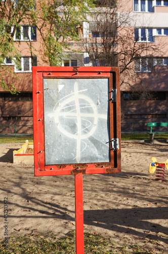 Apartment block with a metal sign standing near it photo