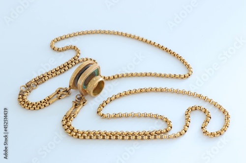 gold necklace on light​ green​ background​