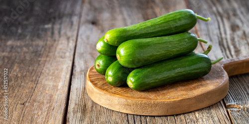 fresh ripe cucumbers on wood background. Copy space