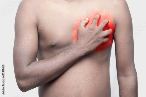 a black man holding his chest by hand for chest pain.