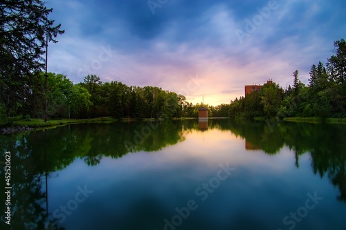 Fototapeta Naklejka Na Ścianę i Meble -  Sunrise Glowing Over A Summer Park Lake