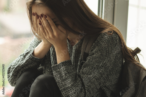 harassment student,young woman cries at school because of sexual molestation from male teachers, upset depressed teenager photo