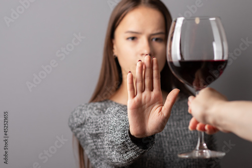 refuse alcohol, stop liquor, teenager shows a sign of rejection of wine with her hand photo