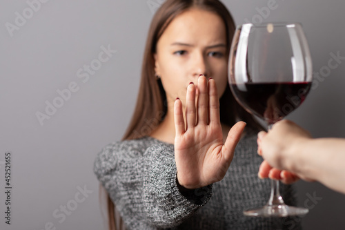 Canvas Print refuse alcohol, stop liquor, teenager shows a sign of rejection of wine with her