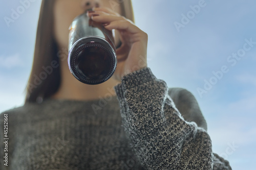 teenager alcohol,minor girl drinking beer in a bottle on the street with friends photo