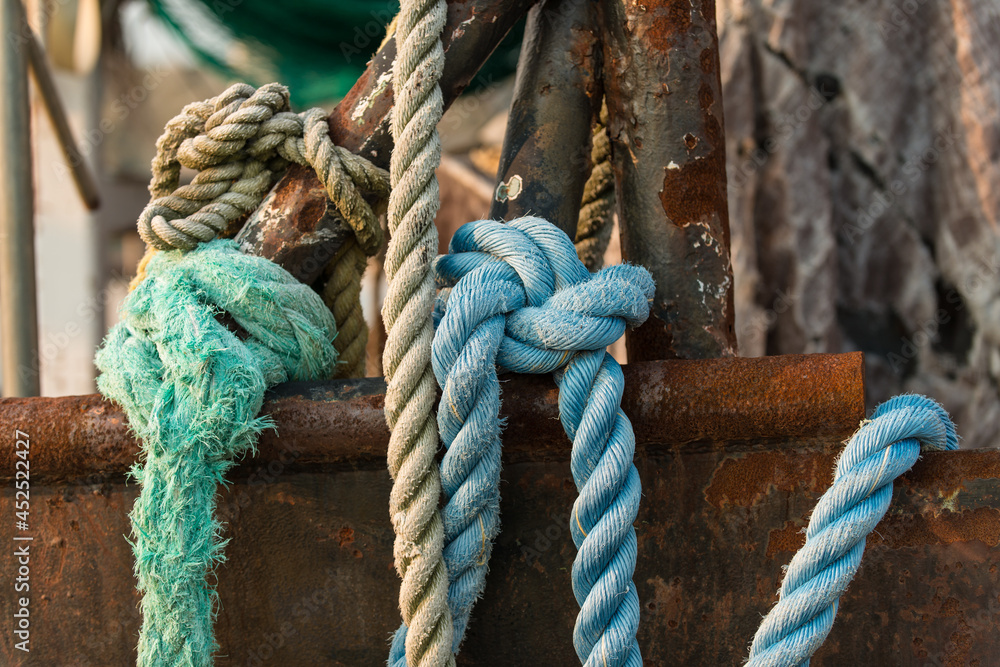Φωτογραφία Knotted blue rope laying over the side of a rusting frame and hull of a deep sea
