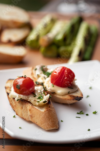 Bruschetta with baked camembert cheese, sauce and herbs