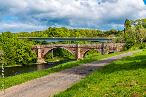A view towards the Medieval bridge and modern road bridge at Leaderfoot in Scotland on a summers day 