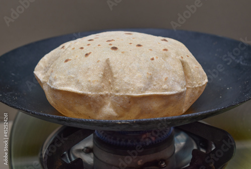 Indian soft phulka Chapati (roti) on non stick tawa also known as tortilla. photo