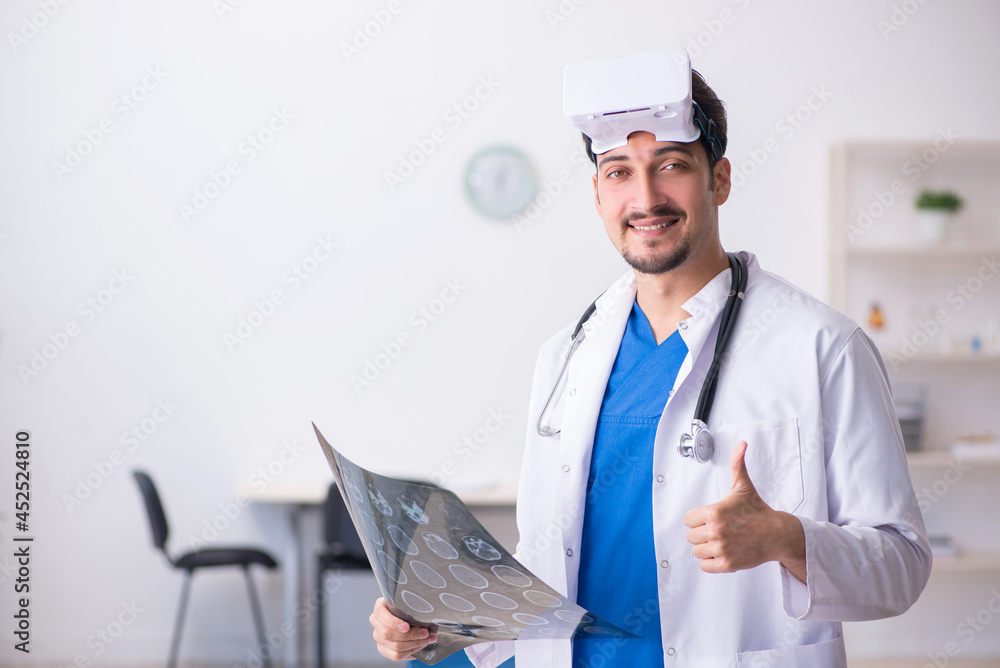 Young male doctor wearing virtual glasses in the clinic