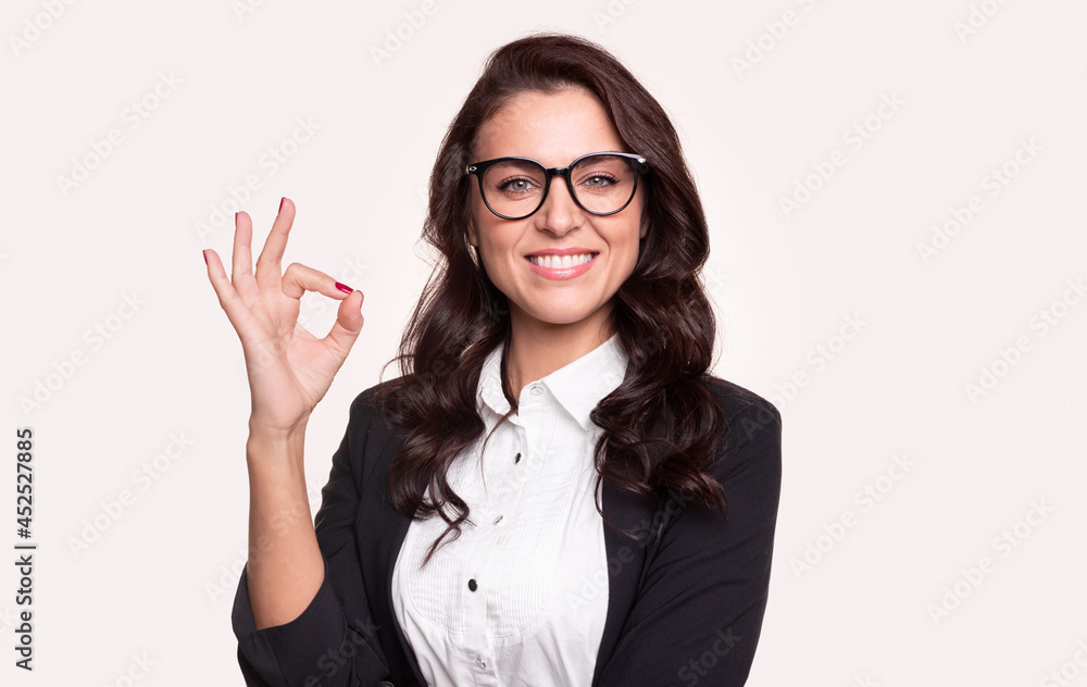 Happy woman in glasses showing OK gesture Happy woman in glasses showing OK gesture