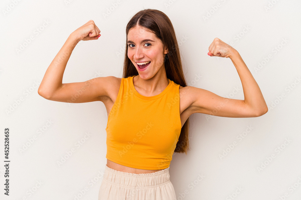 Young caucasian woman isolated on white background showing strength gesture with arms, symbol of feminine power Young caucasian woman isolated on white background showing strength gesture with arms, symbol of feminine power