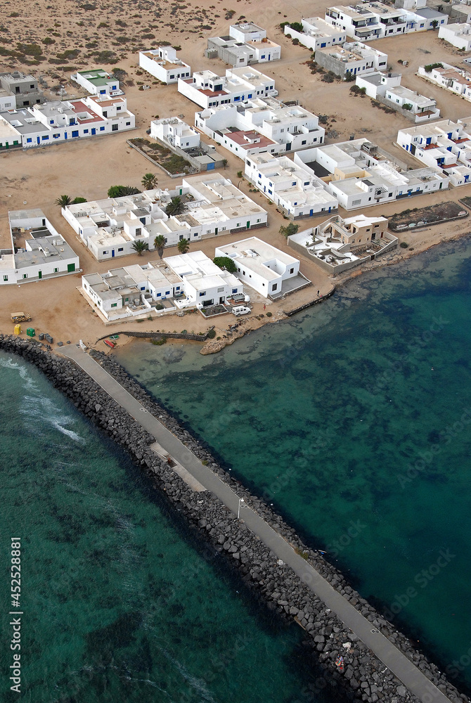 Fotografía aérea de espigón portuario y pueblo de la Caleta del Sebo en la isla de La Graciosa, Canarias