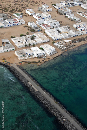 Fotografía aérea de espigón portuario y pueblo de la Caleta del Sebo en la isla de La Graciosa, Canarias